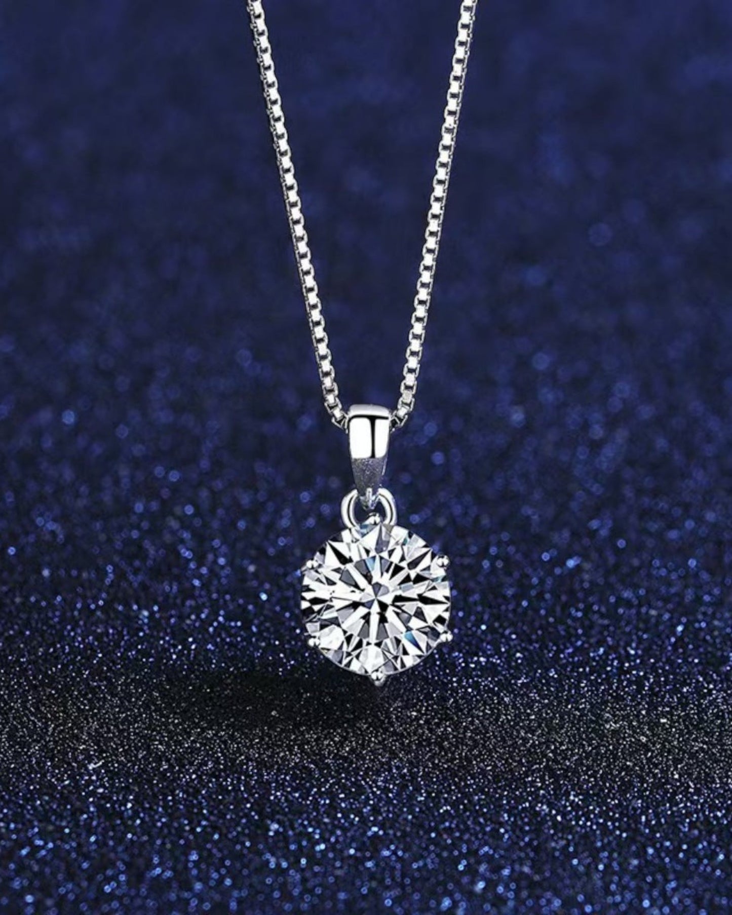 LUMIOR minimalist 1 karaat moissanite hanger ketting van 925 sterling zilver tegen een donkerblauwe achtergrond.