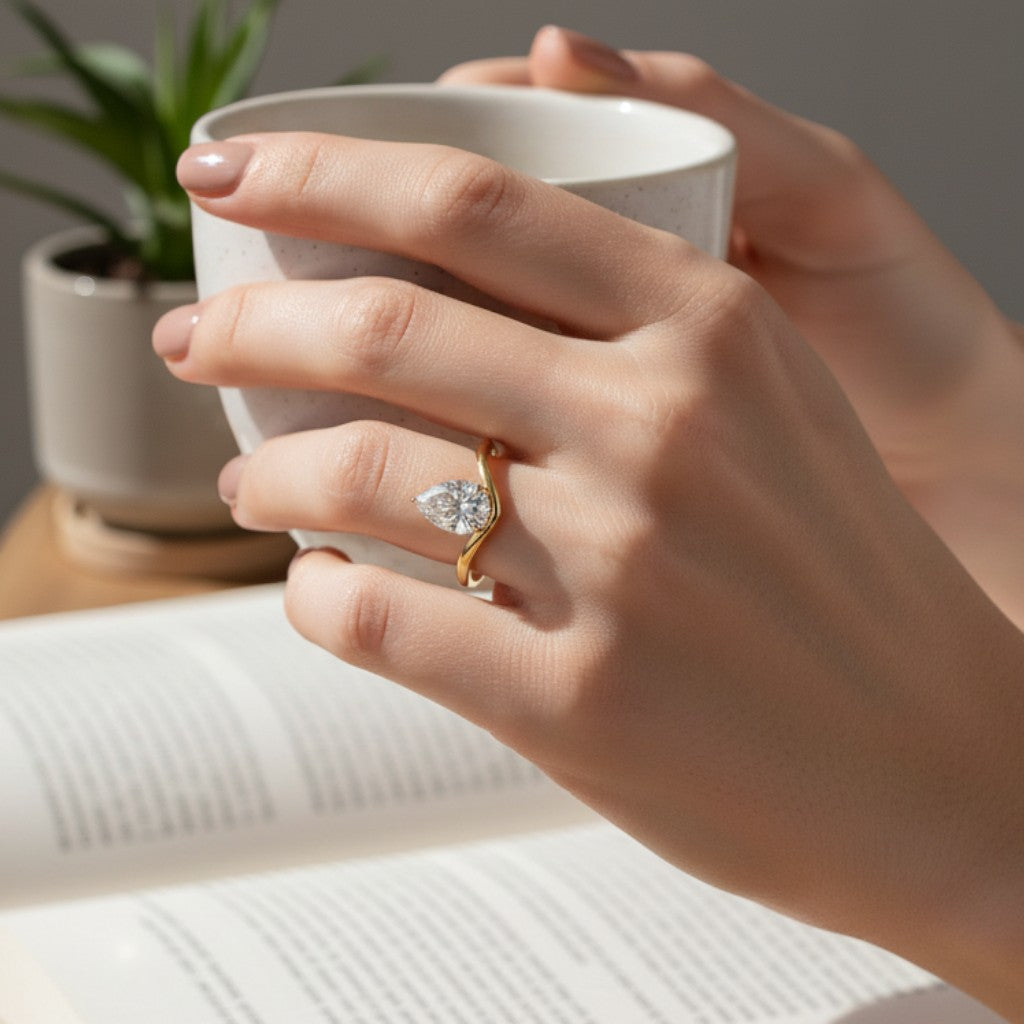 LUMIOR Aria™ ring met 1.25 karaat peervormige moissaniet in 18K geelgouden plating en een V-vormige band.