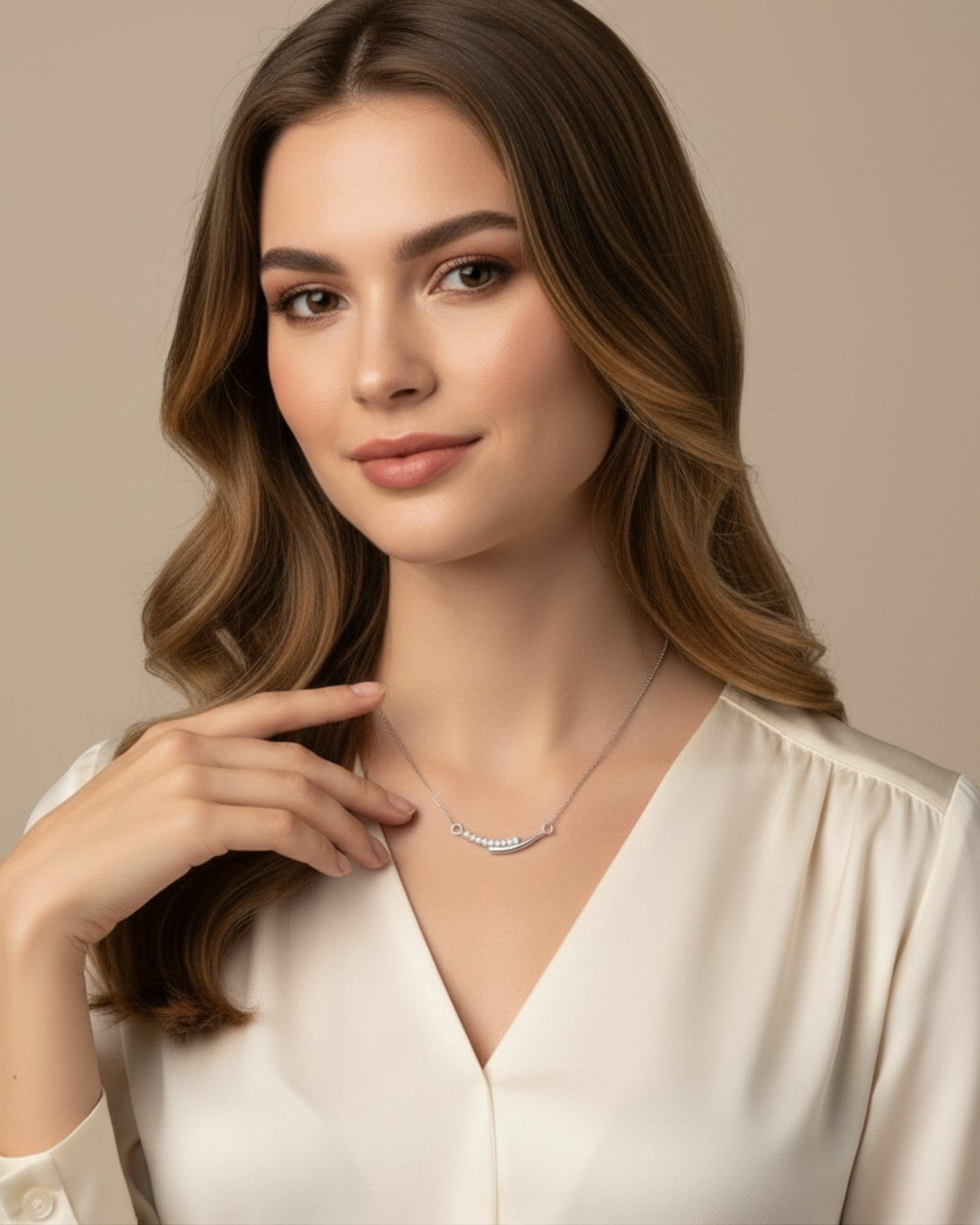 Model draagt LUMIOR Aura ketting van 925 sterling zilver met minimalistische hanger en glinsterende steentjes.