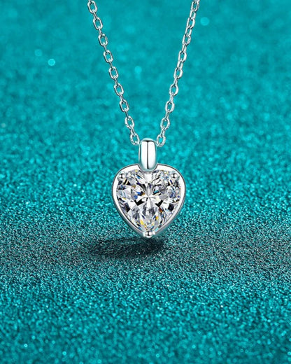 LUMIOR Eternal Heart ketting met 2 karaat moissaniet in 925 sterling zilver op een glinsterende blauwe achtergrond.