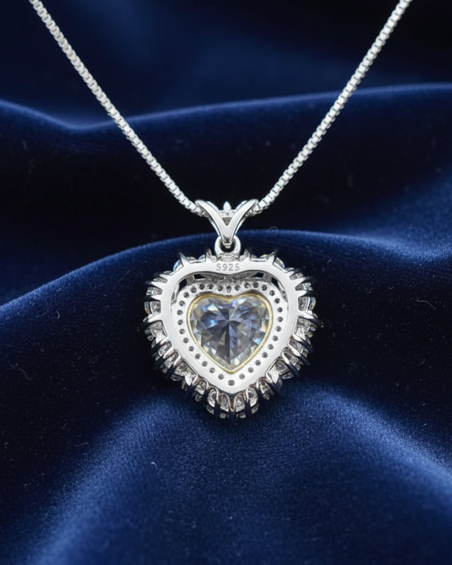 LUMIOR 5 karaat hartvormige moissaniet ketting van 925 sterling zilver met platina plating op blauw fluweel.
