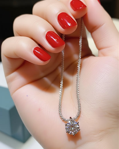 LUMIOR 1 karaat moissanite halo hanger ketting van 925 sterling zilver met platina plating in een hand gehouden.