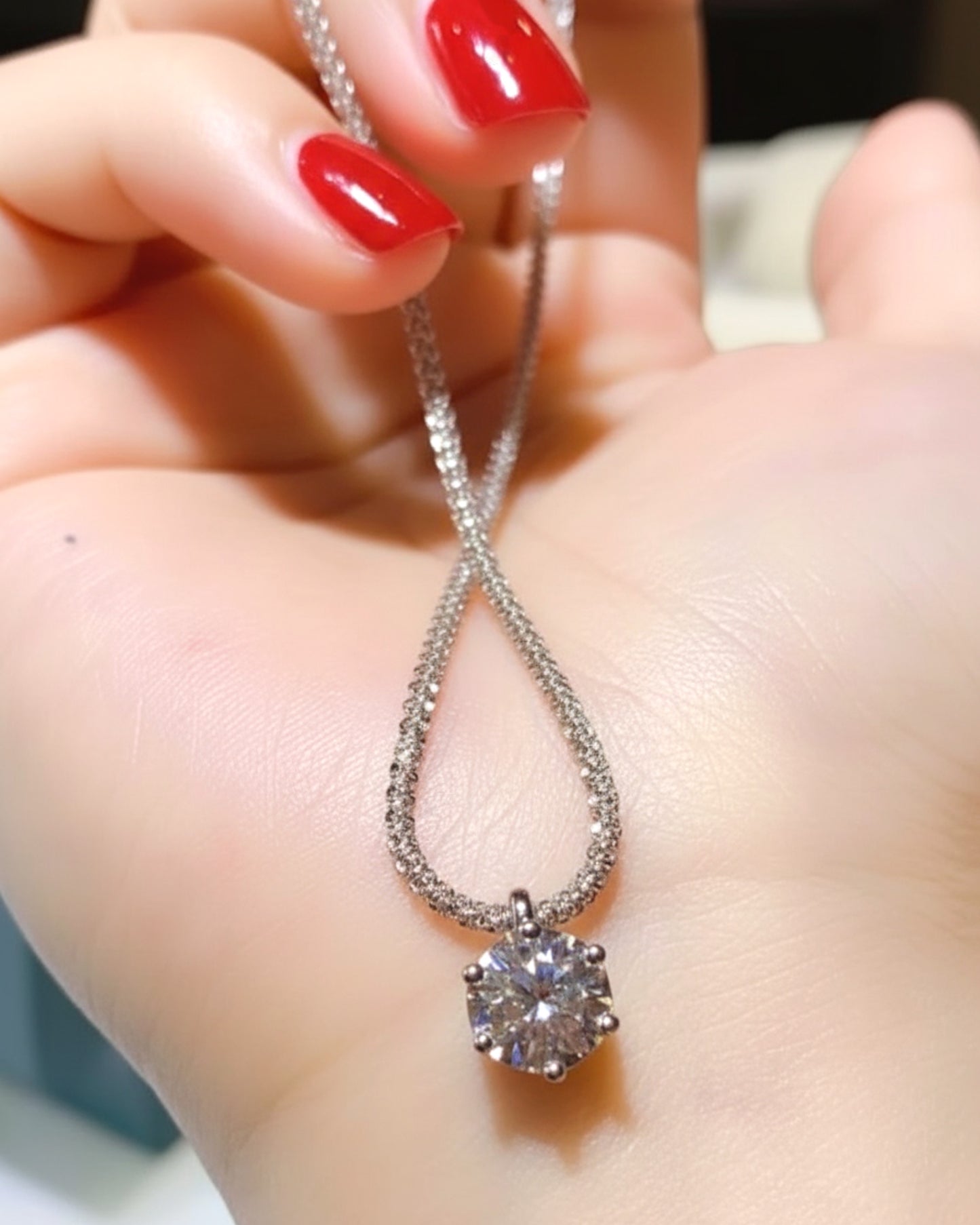 LUMIOR 1 karaat moissanite halo hanger ketting van 925 sterling zilver met platina plating in een hand gehouden.