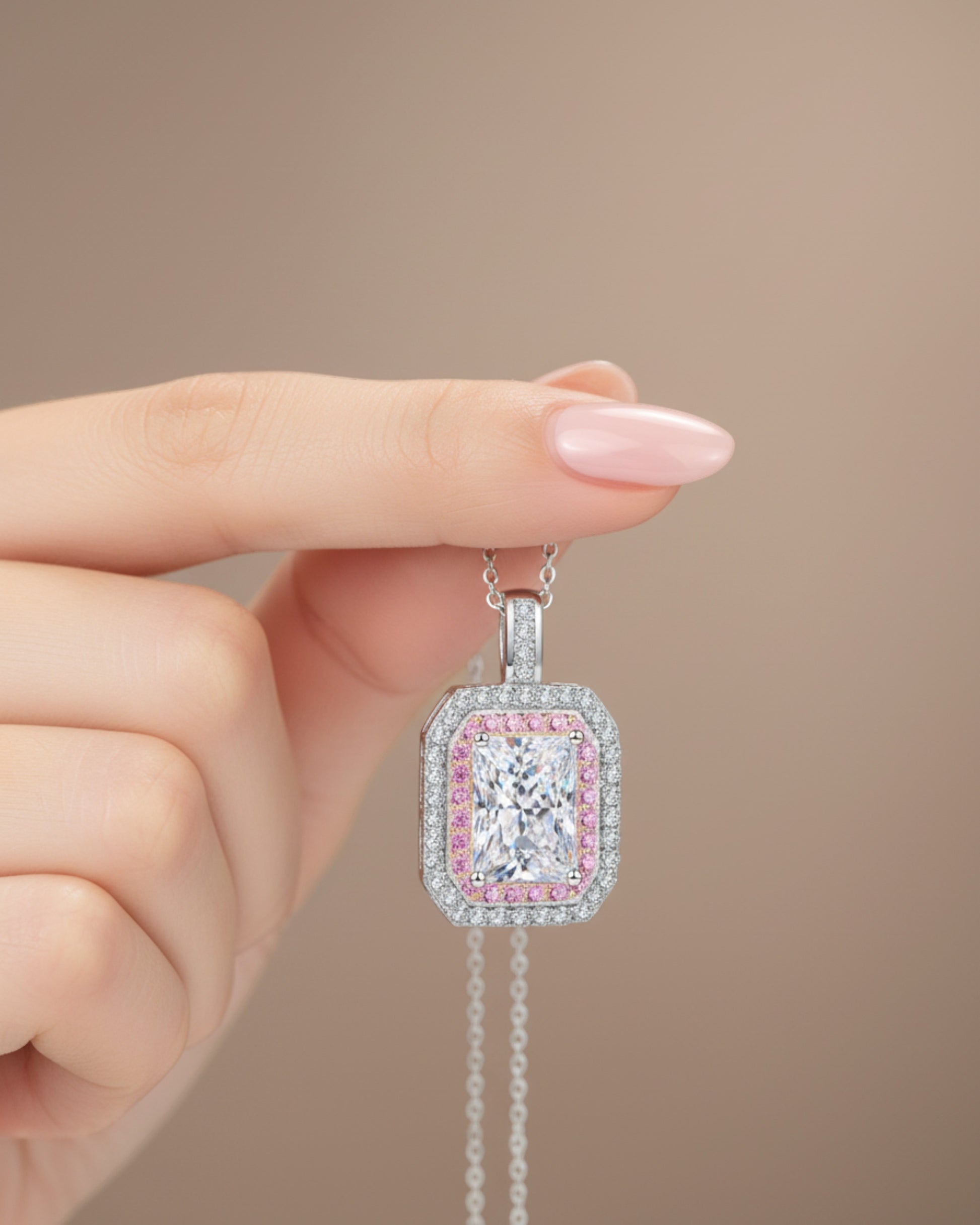 LUMIOR 1 karaat moissanite hanger in 925 sterling zilver met roze accentstenen, vastgehouden door een hand.