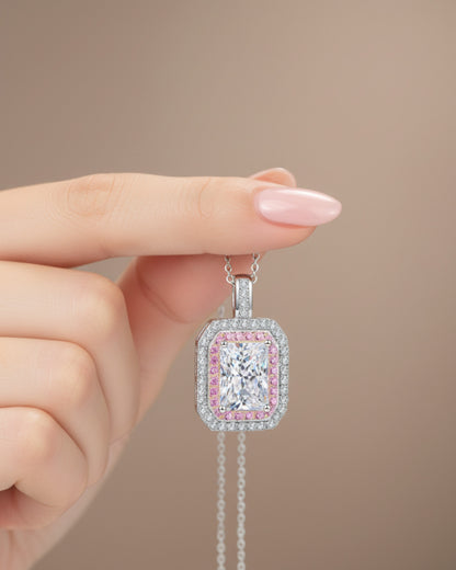 LUMIOR 1 karaat moissanite hanger in 925 sterling zilver met roze accentstenen, vastgehouden door een hand.