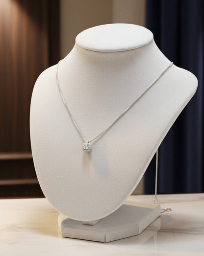 LUMIOR minimalist 0.5 karaat moissanite hanger ketting van 925 sterling zilver op een witte sieradenhouder.