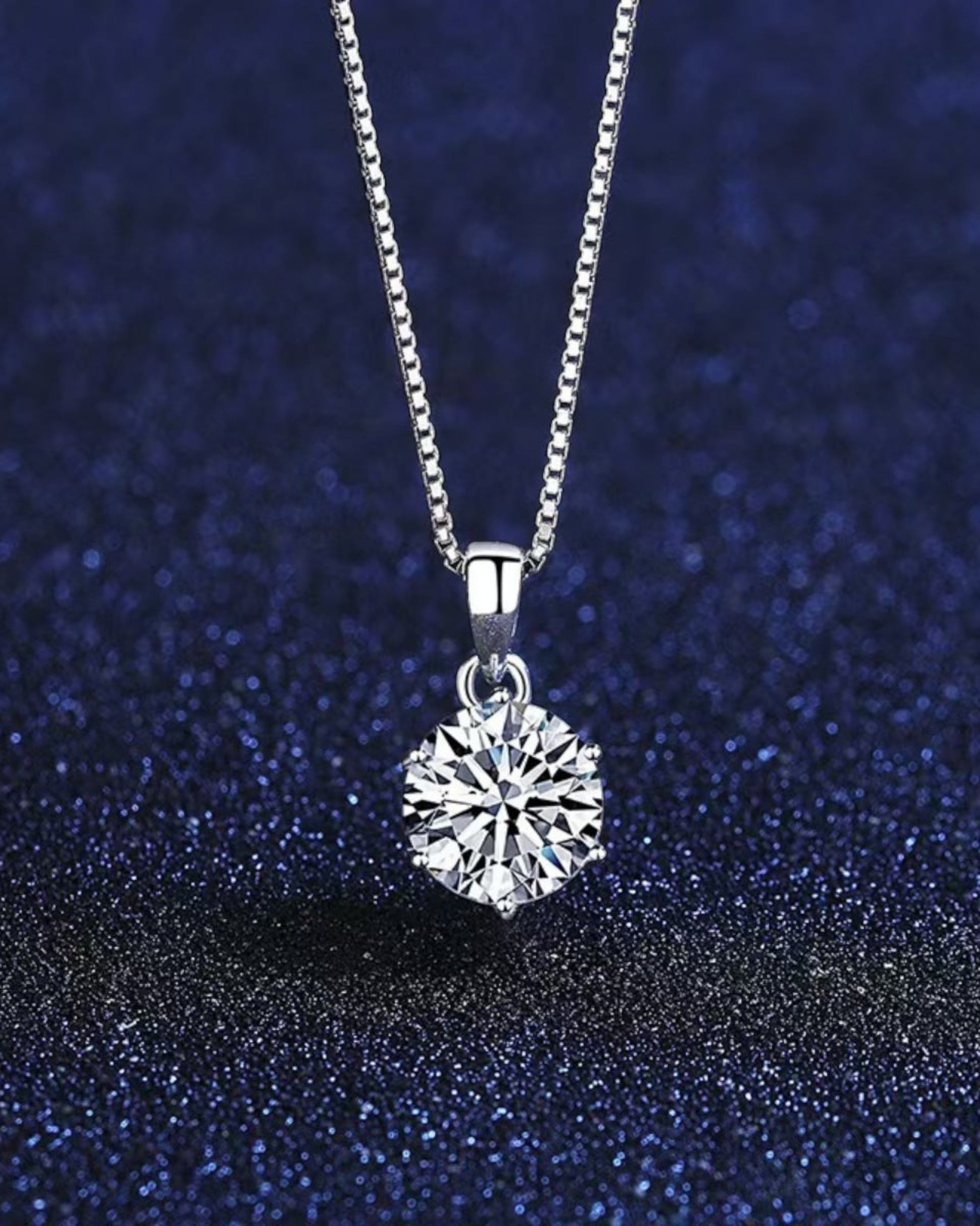 LUMIOR minimalist 1 karaat moissanite hanger ketting van 925 sterling zilver tegen een donkerblauwe achtergrond.