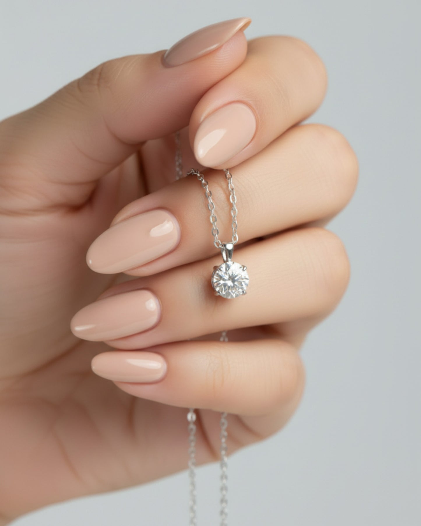 LUMIOR 1 karaat moissanite ketting van sterling zilver met een minimalistische hanger in een hand gehouden.