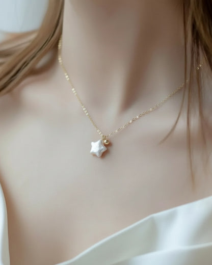 LUMIOR gouden ketting met een ster van parelmoer en een klein gouden bolletje. Verstelbare lengte.
